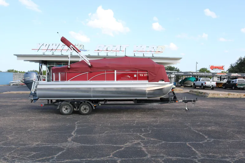 Slide: The Image of 2013 Bennington 22 SLX pontoon boat with red cover on a trailer at a boat yard. - 26