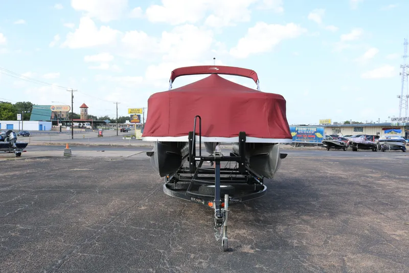 Slide: The Image of 2013 Bennington 22 SLX pontoon boat with red cover on trailer in parking lot. - 27