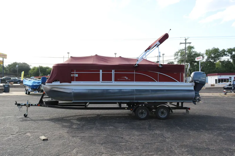 Slide: The Image of 2013 Bennington 22 SLX pontoon boat with red cover on a trailer in a parking lot. - 28