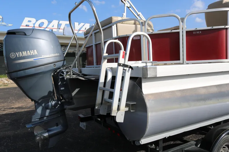 Slide: The Image of 2013 Bennington 22 SLX pontoon boat with Yamaha outboard motor, parked at a marina. - 7