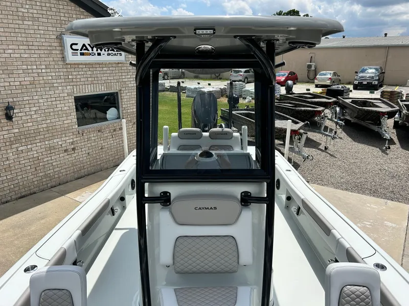 Slide: The Image of 2026 Caymas 28 HB boat with sleek design, parked outdoors near dealership. - 12