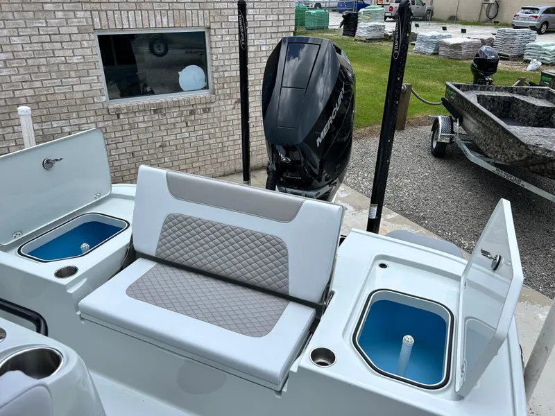Slide: The Image of 2026 Caymas 28 HB boat interior with seating, storage compartments, and Mercury outboard motor. - 16