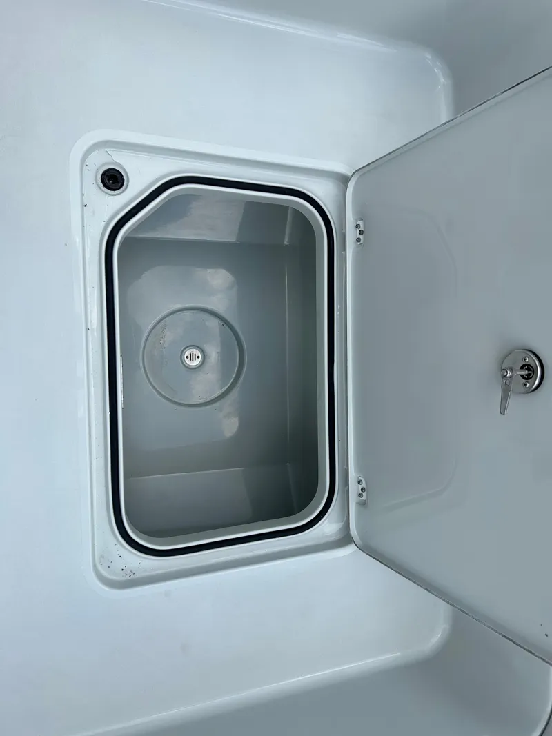 Slide: The Image of Open storage compartment on 2026 Caymas 28 HB boat, featuring a secure latch. - 27