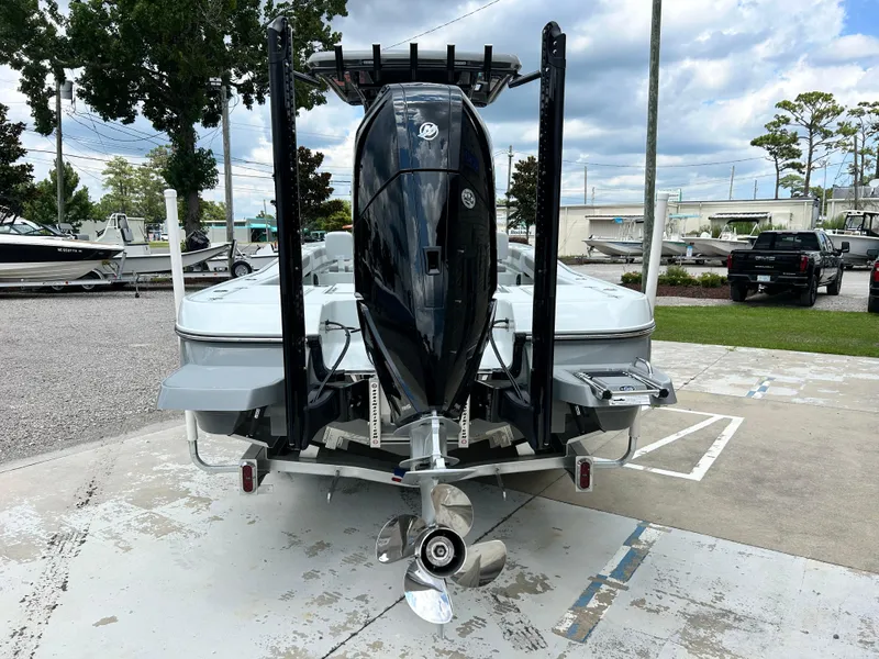 Slide: The Image of 2026 Caymas 28 HB boat with powerful outboard motor, parked outdoors on a cloudy day. - 5