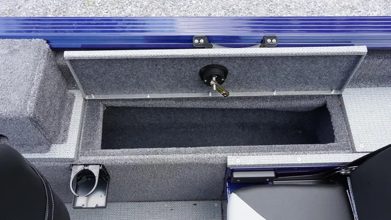 Slide: The Image of 2025 G3 Angler V164 C boat storage compartment with gray carpet and blue trim. - 30