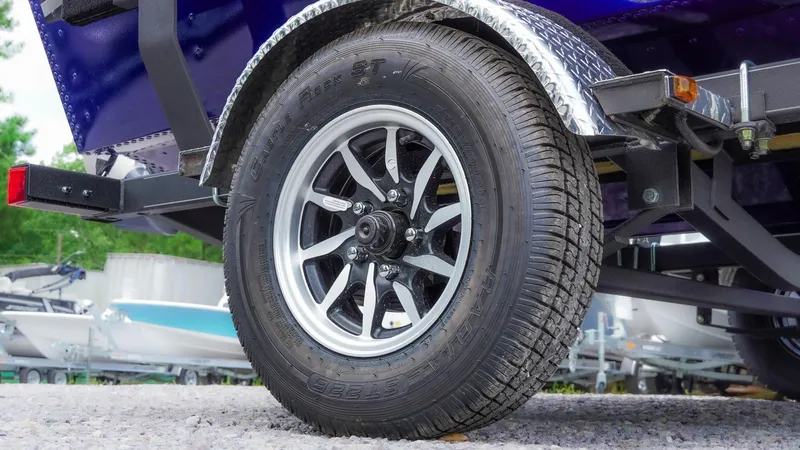 Slide: The Image of 2025 G3 Angler V164 C trailer wheel with radial tire on gravel surface. - 33