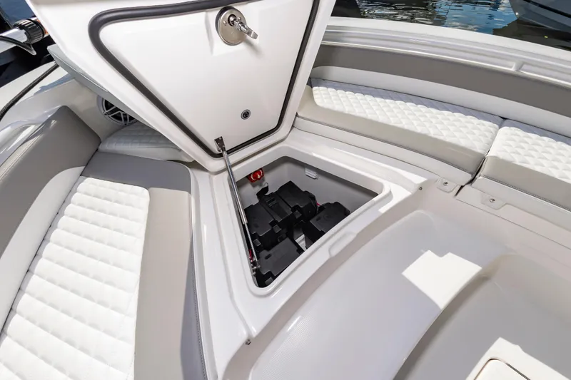 Slide: The Image of 2026 Regulator 26XO boat interior with open storage compartment and cushioned seating. - 19