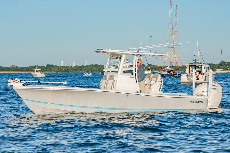 Slide: The Image of 2026 Regulator 26XO boat cruising on a sunny day with multiple boats in the background. - 1