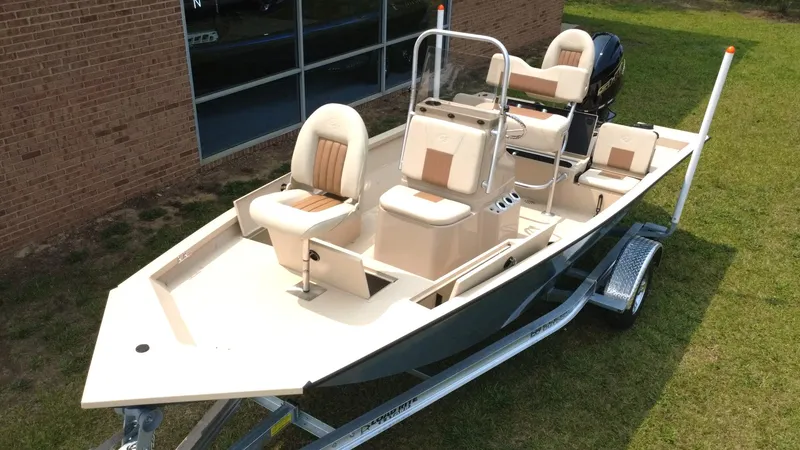 Slide: The Image of 2025 G3 Bay 19 GX boat on trailer, beige interior, parked on grass. - 4