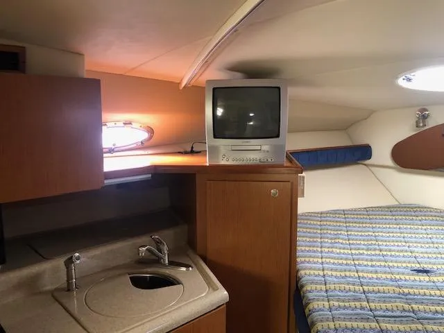 Slide: The Image of 2004 Cruisers Yachts 280 Express cabin with TV, sink, and bed. - 15