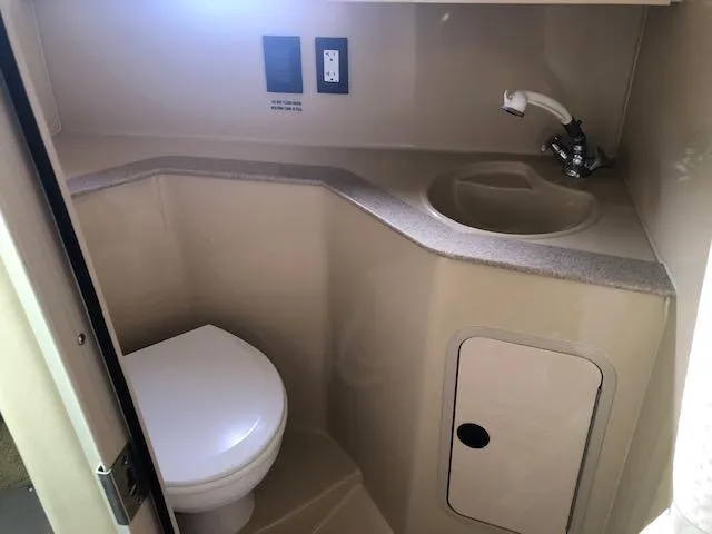 Slide: The Image of 2004 Cruisers Yachts 280 Express bathroom with toilet, sink, and storage compartment. - 19