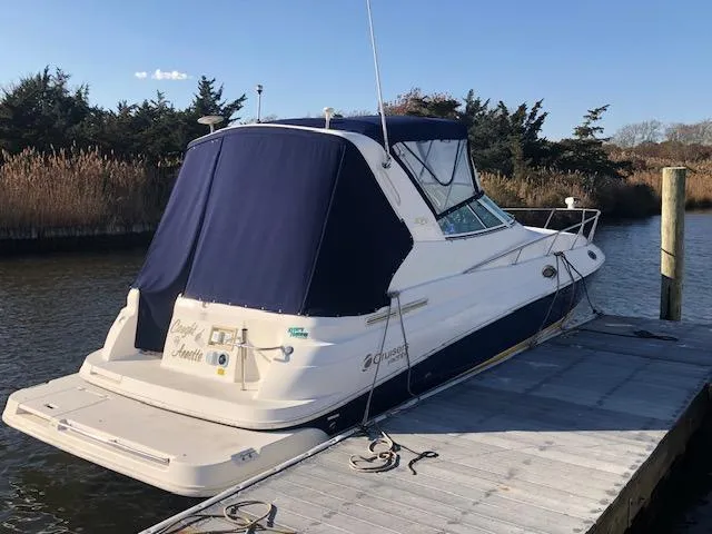Slide: The Image of 2004 Cruisers Yachts 280 Express docked, featuring a blue canopy and sleek design. - 2