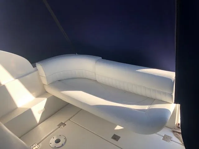 Slide: The Image of 2004 Cruisers Yachts 280 Express interior with white seating and blue canopy. - 4