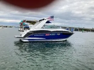 Slide: The Image of 2019 Monterey 295 Sport Yacht on water, American flag, cloudy sky. - 17