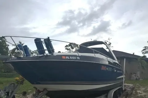 Slide: The Image of 2019 Monterey 295 Sport Yacht on trailer, parked outdoors under cloudy sky. - 18