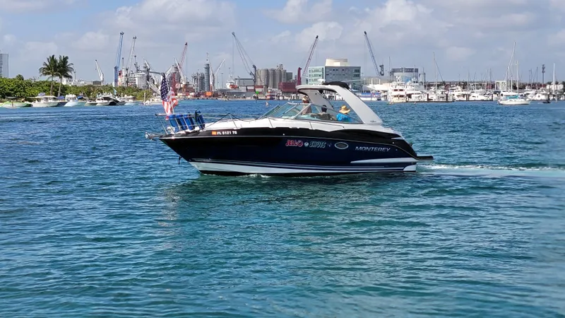 Slide: The Image of 2019 Monterey 295 Sport Yacht cruising in a busy harbor with cityscape background. - 19