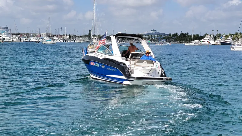 Slide: The Image of 2019 Monterey 295 Sport Yacht cruising in a marina with clear blue skies. - 21
