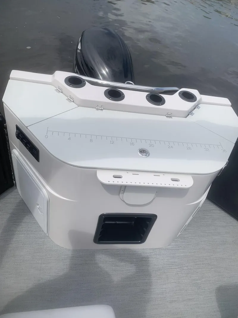 Slide: The Image of 2026 Godfrey Sweetwater 2286 FS boat console with rod holders and measurement markings. - 5