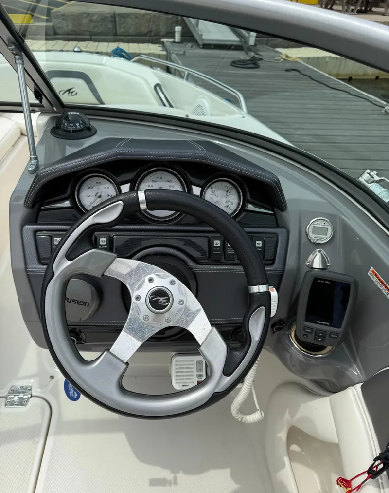 Slide: The Image of Steering wheel and dashboard of a 2012 Monterey 204FS boat at a dock. - 7