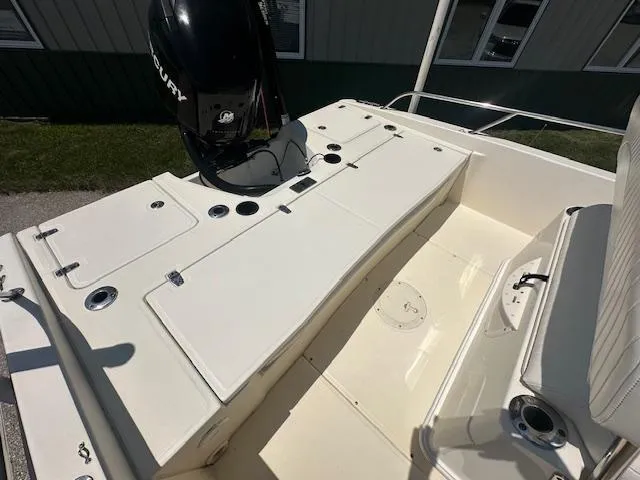 Slide: The Image of 2007 Boston Whaler 200 Dauntless boat deck with Mercury engine, featuring seating and storage compartments. - 8
