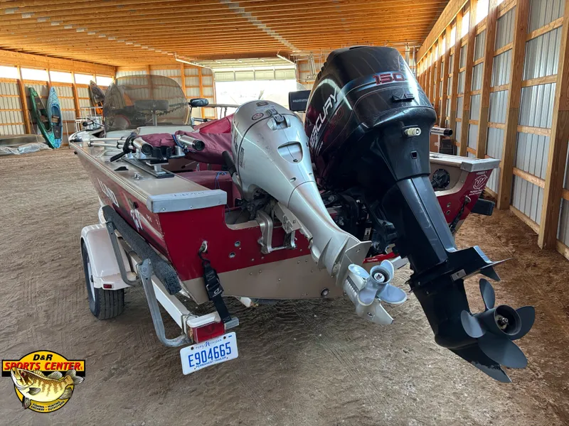 Slide: The Image of 1997 Lund 1900 Pro-V LE boat with dual outboard motors in a storage facility. - 3