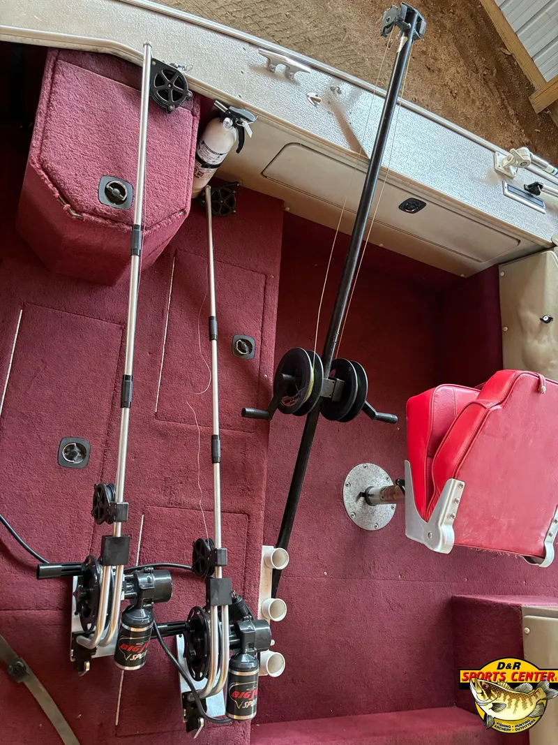 Slide: The Image of 1997 Lund 1900 Pro-V LE boat interior with fishing rods and red seating. - 4