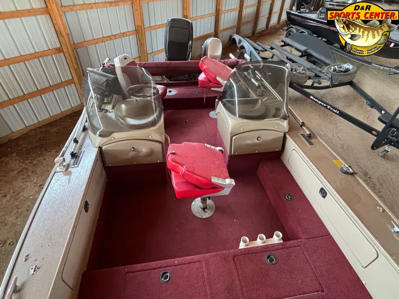Slide: The Image of 1997 Lund 1900 Pro-V LE boat interior with red seating and dual windshields in storage. - 6