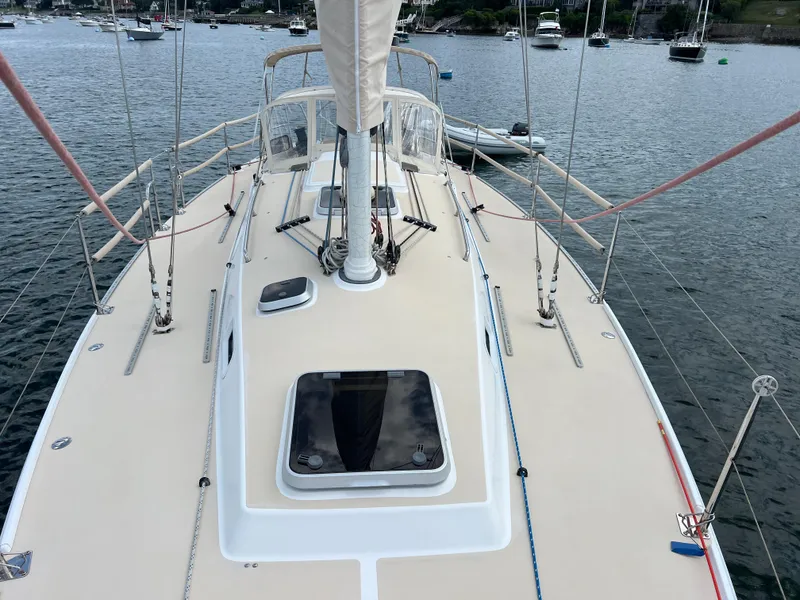 Slide: The Image of 2001 J Boats J/120 sailboat deck view with rigging and hatches, moored in a harbor. - 11