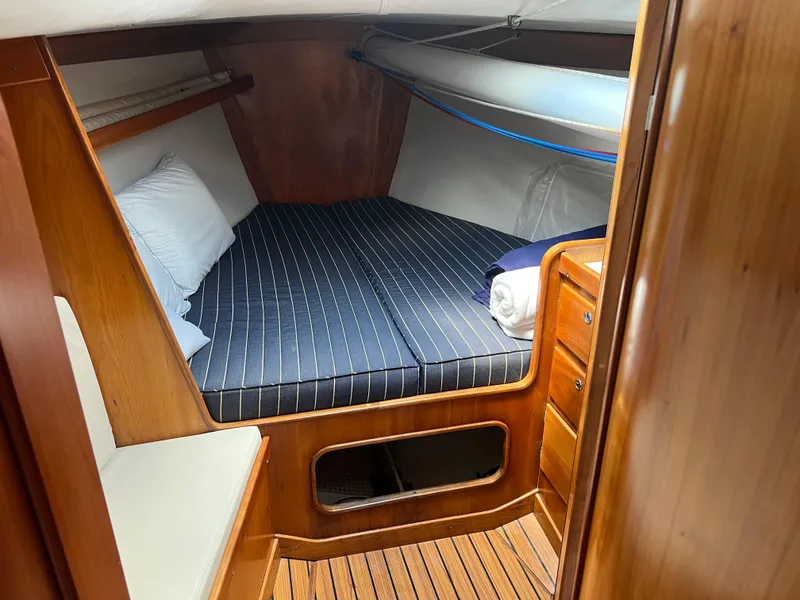 Slide: The Image of Cozy cabin interior of 2001 J Boats J/120 with striped bedding and wooden finish. - 17
