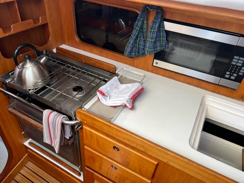 Slide: The Image of Galley kitchen in 2001 J Boats J/120 sailboat with stove, microwave, and sink. - 18