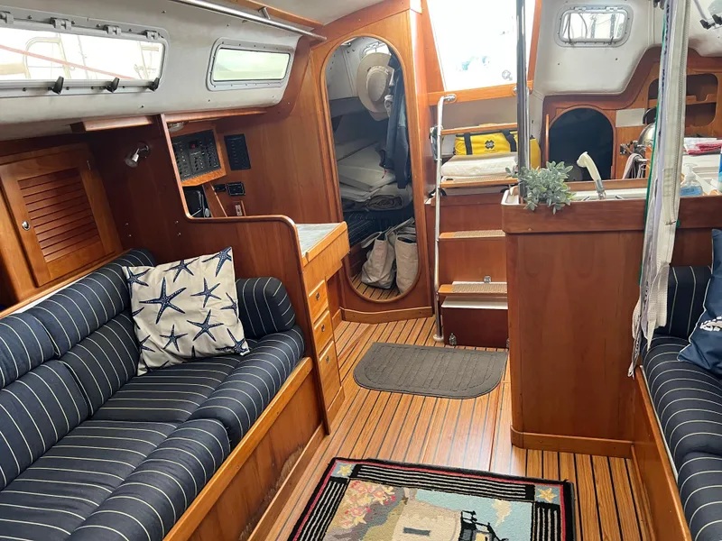Slide: The Image of Interior of 2001 J Boats J/120 sailboat with striped seating and wooden finishes. - 24