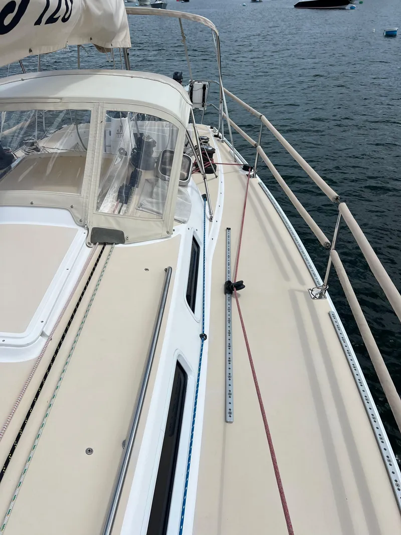Slide: The Image of 2001 J Boats J/120 sailboat deck with rigging, docked on calm water. - 9