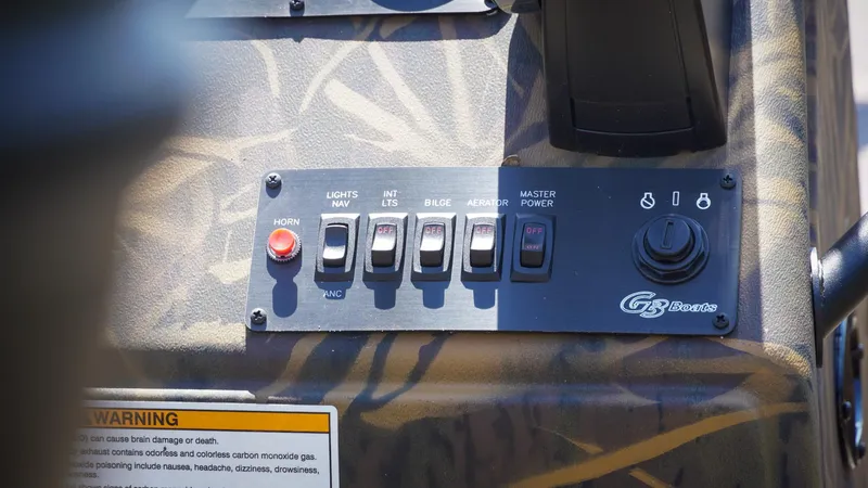 Slide: The Image of Control panel of 2025 G3 Gator Tough 20 CC boat with switches and warning label. - 7