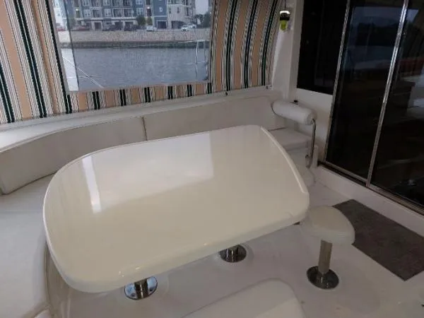 Slide: The Image of Luxurious Leopard 46 yacht interior with sleek white table, striped curtains, and waterfront view. - 10