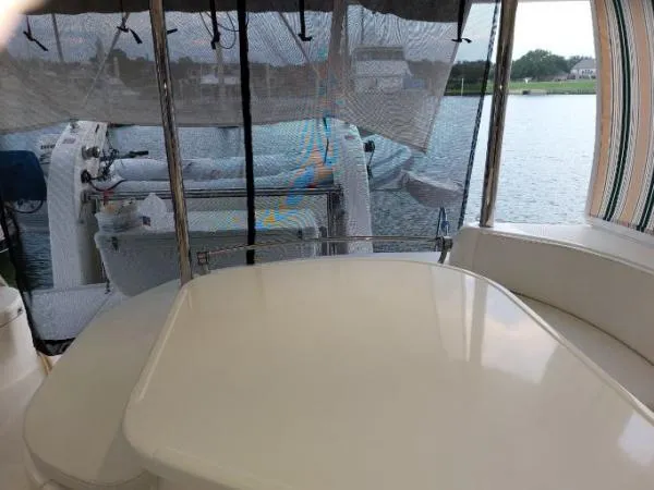 Slide: The Image of 2011 Leopard 46 yacht interior with seating and table, overlooking calm waters. - 11