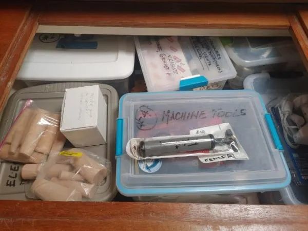 Slide: The Image of Storage compartment with labeled boxes and tools on a Leopard 46, 2011 model. - 25