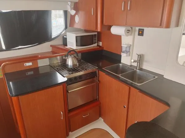 Slide: The Image of Compact kitchen in a 2011 Leopard 46 yacht with stove, microwave, and dual sink. - 3