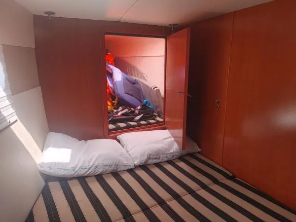 Slide: The Image of Cozy cabin interior of 2011 Leopard 46 yacht with striped bedding and open storage. - 5