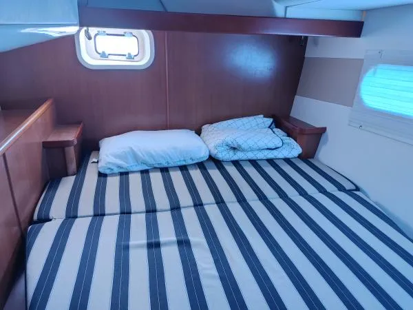 Slide: The Image of Cozy cabin bedroom in 2011 Leopard 46 yacht with striped bedding and wooden accents. - 6