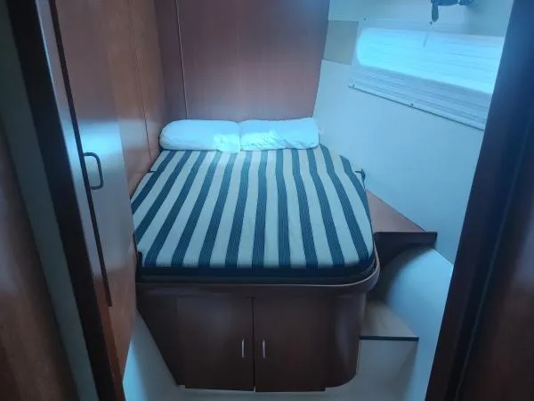 Slide: The Image of Cozy cabin bedroom in 2011 Leopard 46 yacht with striped bedding and wooden furnishings. - 7