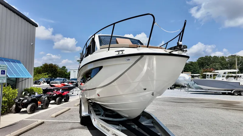 Slide: The Image of 2026 Bayliner Trophy 29 Explorer boat on trailer in sunny dealership lot. - 2