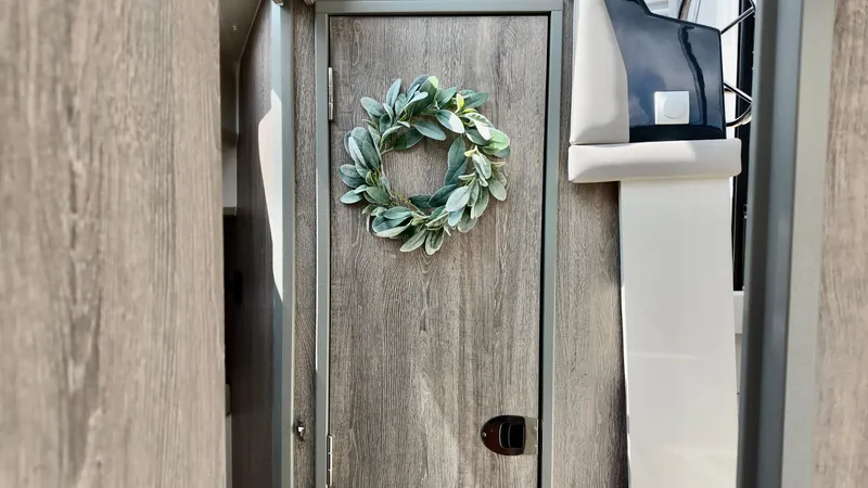 Slide: The Image of Interior of 2026 Bayliner Trophy 29 Explorer with decorative wreath on wooden door. - 23