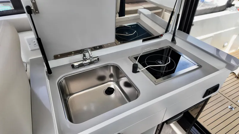 Slide: The Image of Compact kitchen area on 2026 Bayliner Trophy 29 Explorer boat with sink and stove. - 31