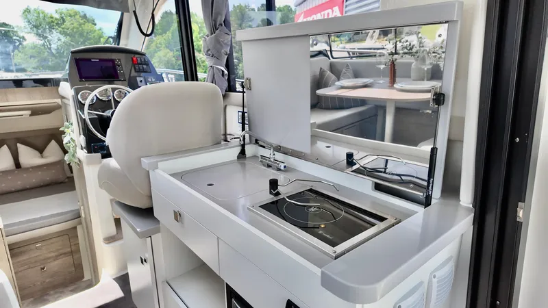 Slide: The Image of Interior of 2026 Bayliner Trophy 29 Explorer, featuring modern helm and compact kitchen area. - 34