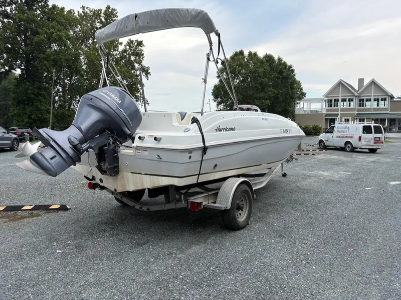 Slide: The Image of 2016 Hurricane 188 boat on trailer with Yamaha outboard motor in parking lot. - 2