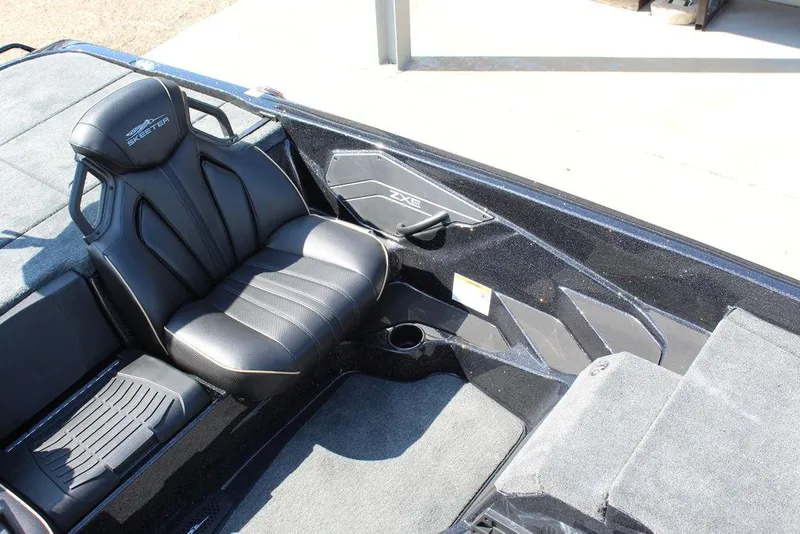 Slide: The Image of 2026 Skeeter ZXE21 boat interior with black seating and carpeted flooring. - 21