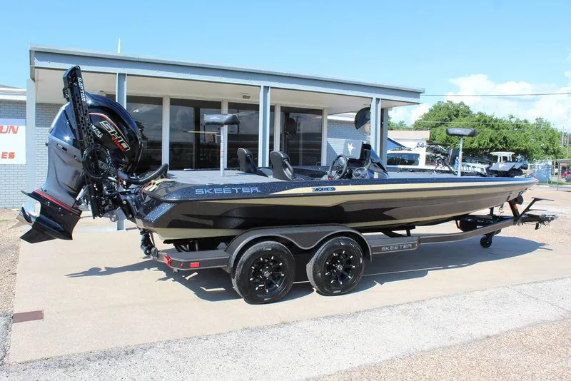 Slide: The Image of 2026 Skeeter ZXE21 boat on trailer, parked outside dealership under clear sky. - 5