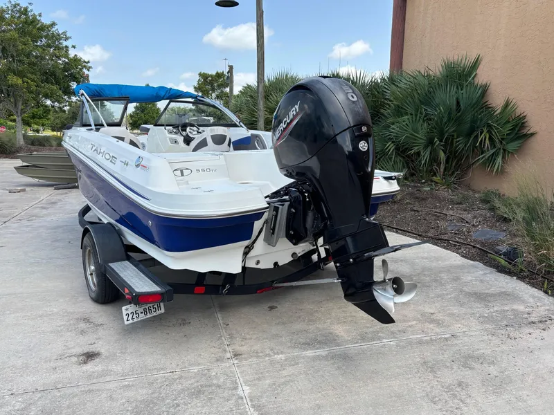 Slide: The Image of 2021 Tahoe 550TF boat on trailer with Mercury outboard motor, parked outdoors. - 13