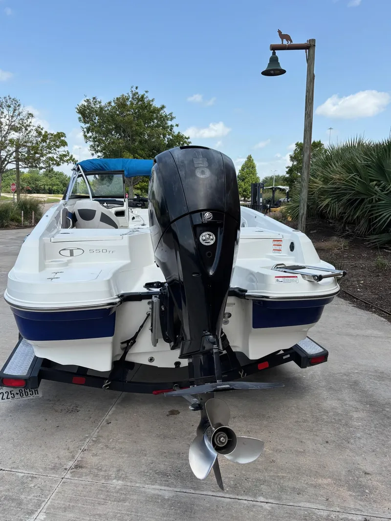 Slide: The Image of 2021 Tahoe 550TF boat on trailer, rear view with outboard motor, parked outdoors. - 5
