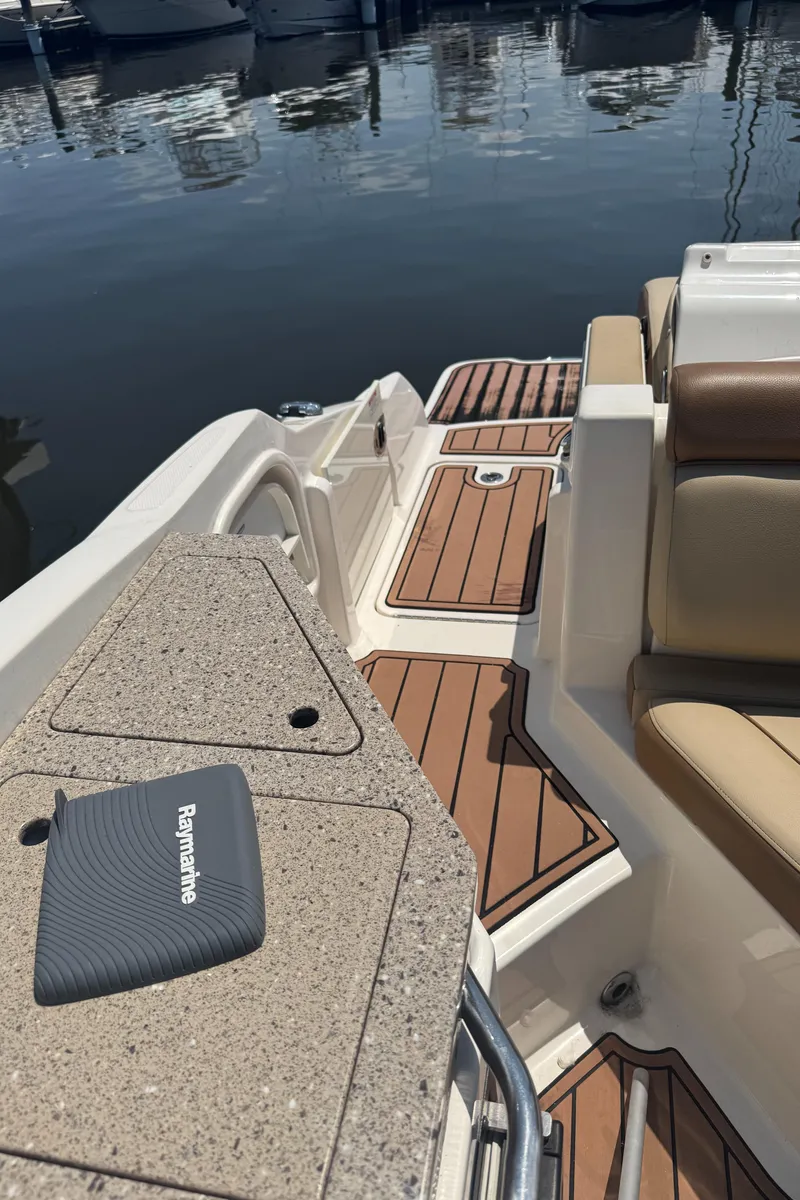 Slide: The Image of 2015 Sea Ray 290 Sundeck boat interior with teak flooring and Raymarine equipment. - 14